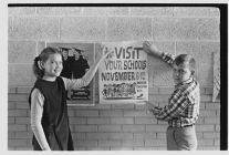 Children with ‘American Education Week' poster 